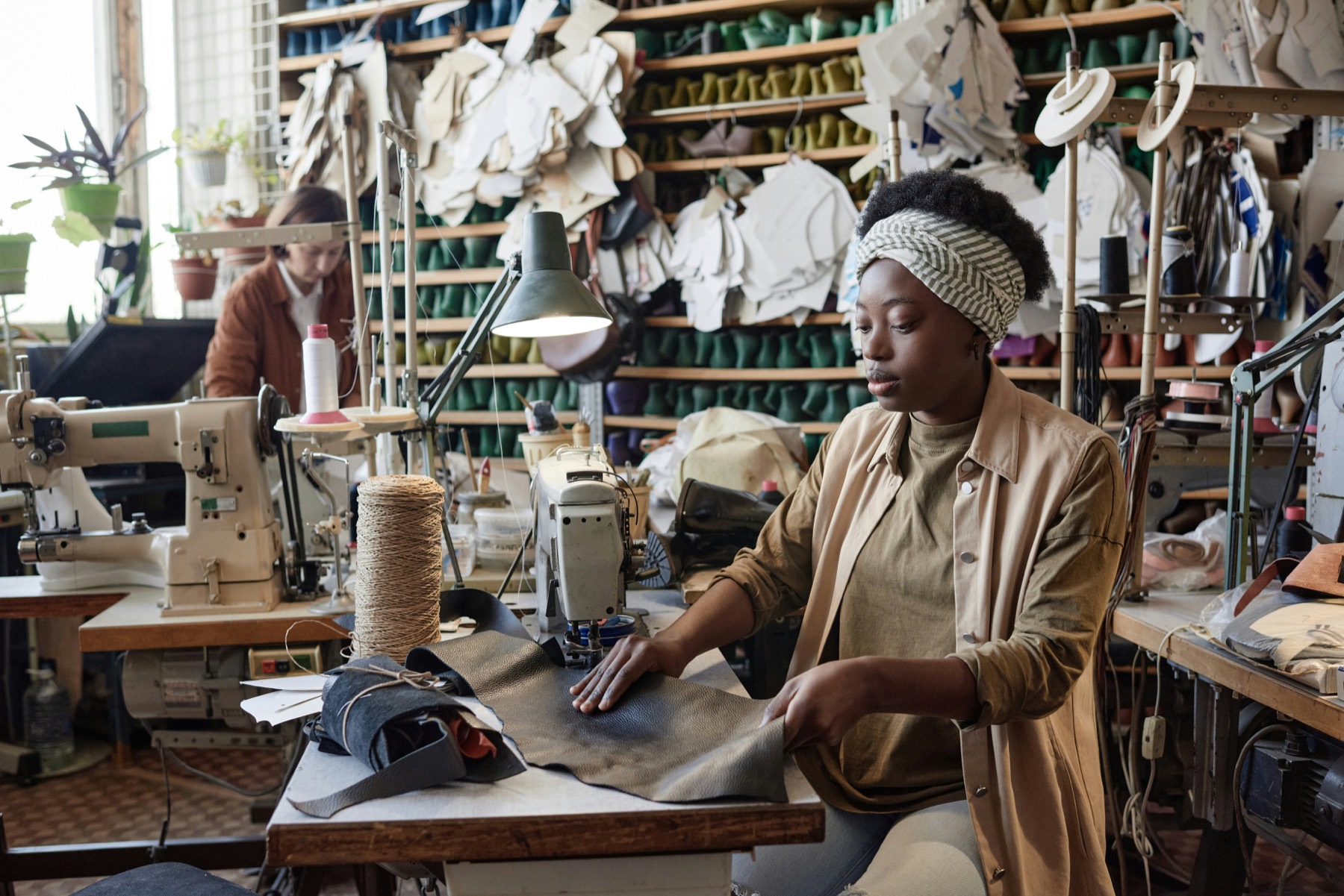 An artisan sewing leather in her workshop