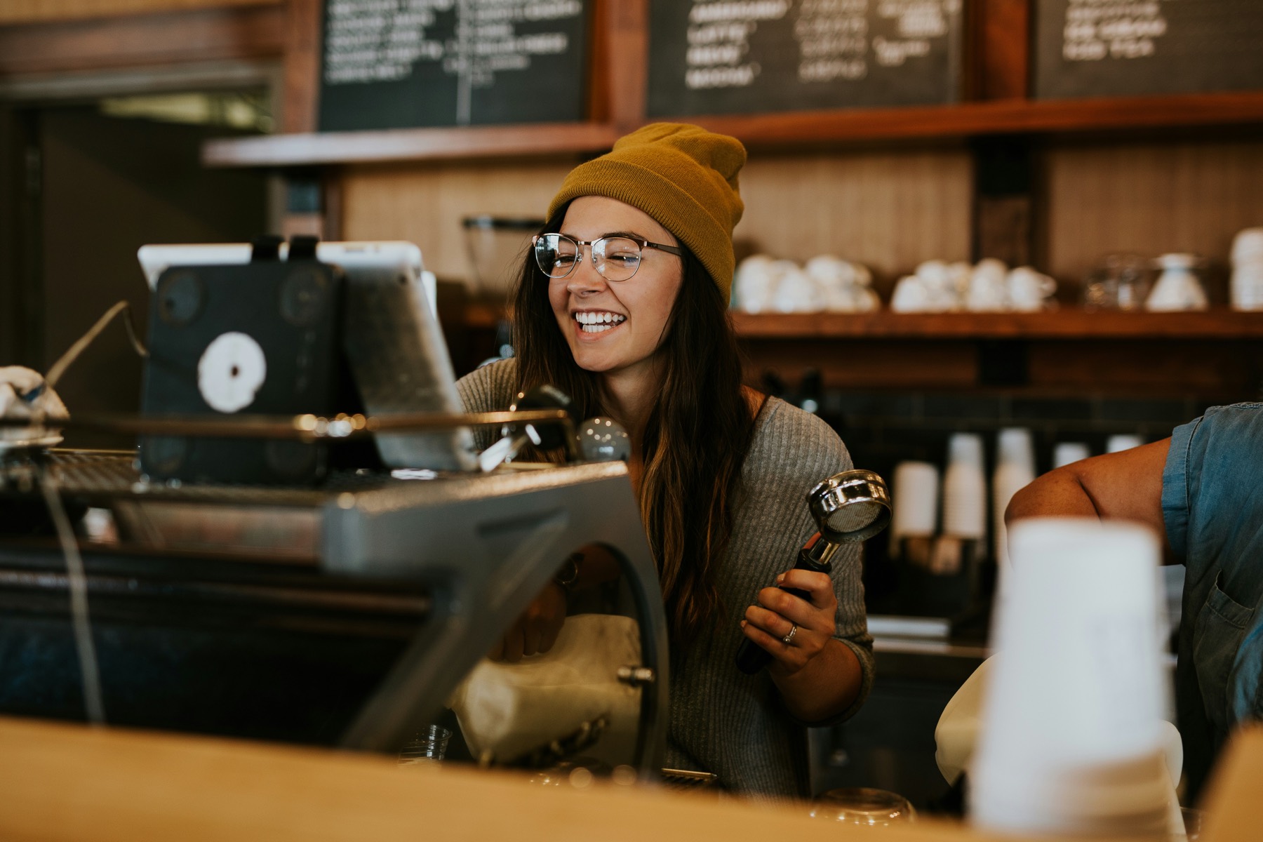 A smiling barista at work in her coffee shop